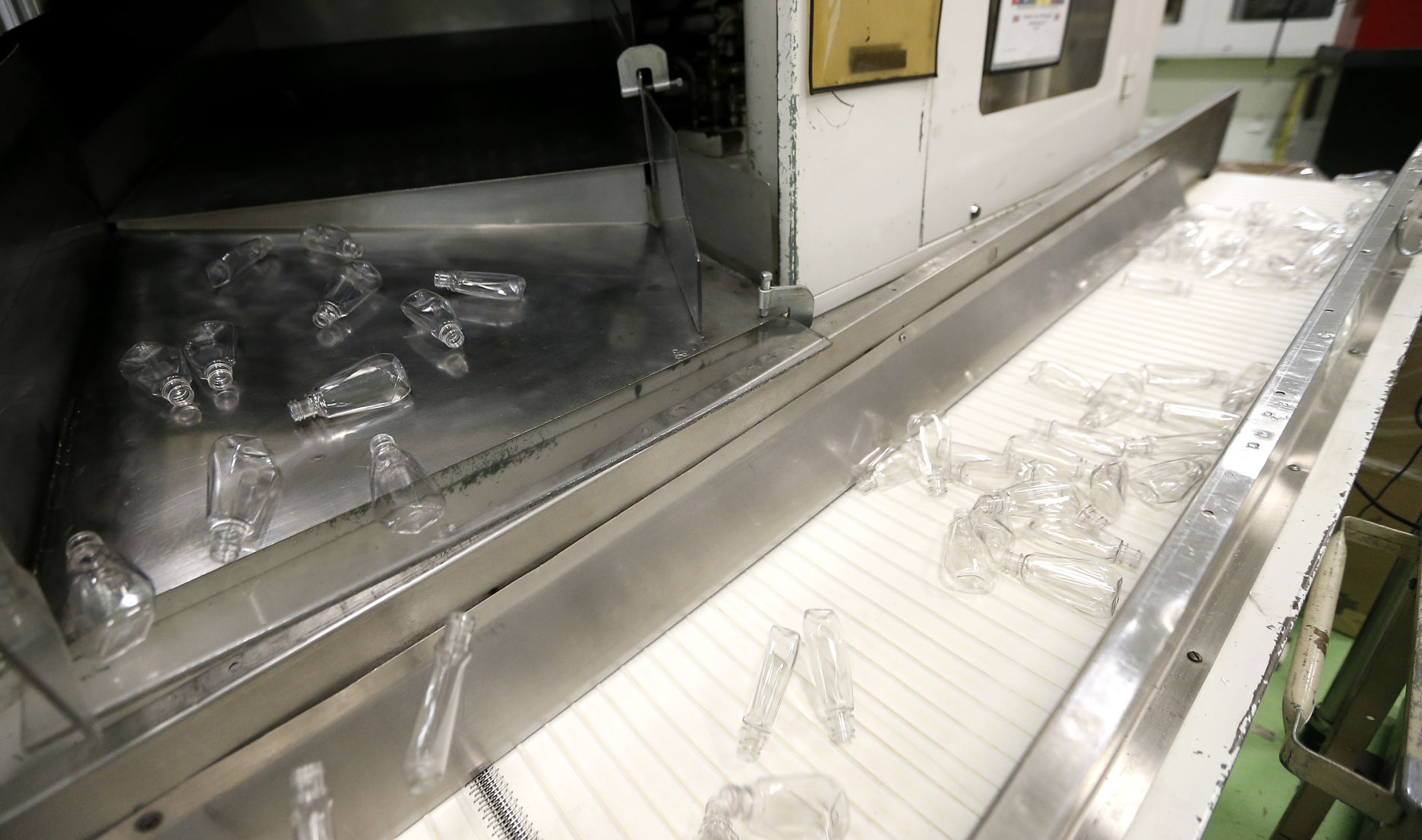 A machine kicks mouthwash bottles onto a conveyor belt inside Berry Plastics located in Peosta, Iowa. PHOTO CREDIT: DAVE KETTERING