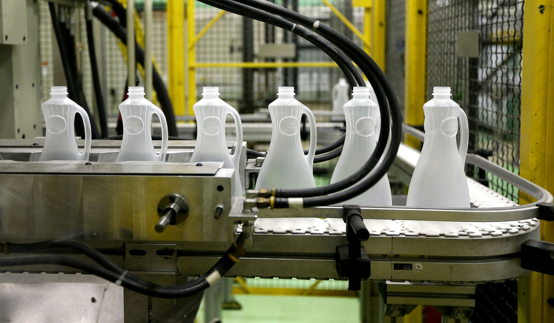 Freshly molded syrup bottles roll off the line. PHOTO CREDIT: DAVE KETTERING