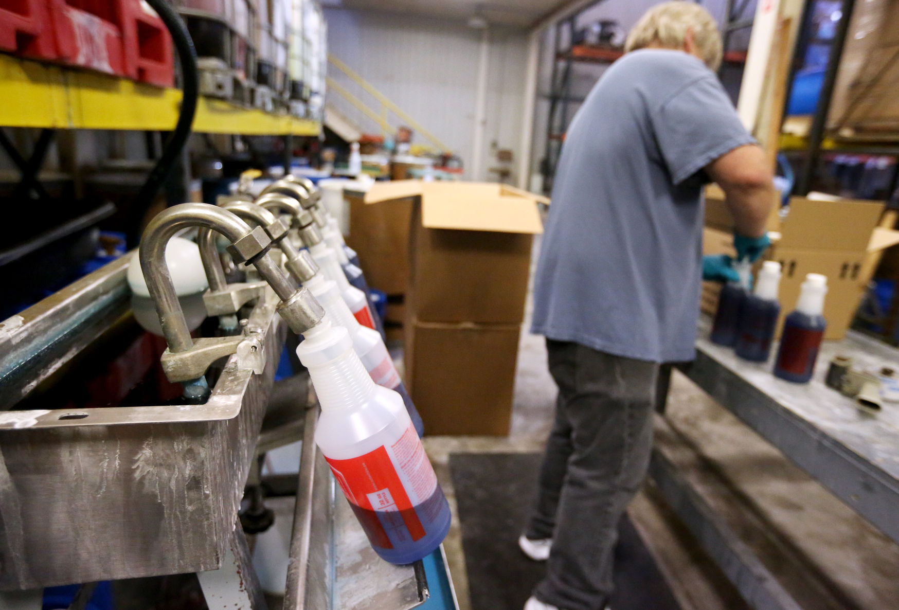 Scott Smith packages beer line cleaner at Higley Industries in Dubuque. PHOTO CREDIT: JESSICA REILLY