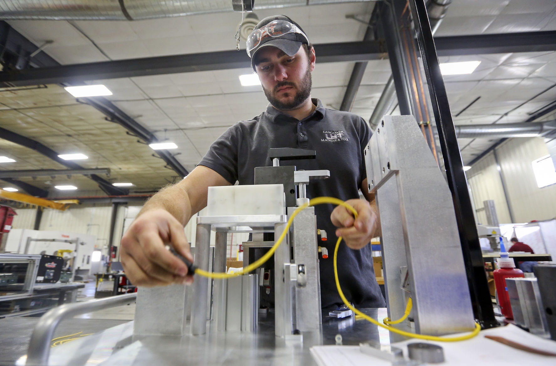 Brian Tucker wires an assembly fixture at Lancaster Machine & Tool. The Wisconsin manufacturer, which began in 1995, has adjusted its procedures, moving from making parts to designing and completing every step in the process.    PHOTO CREDIT: NICKI KOHL