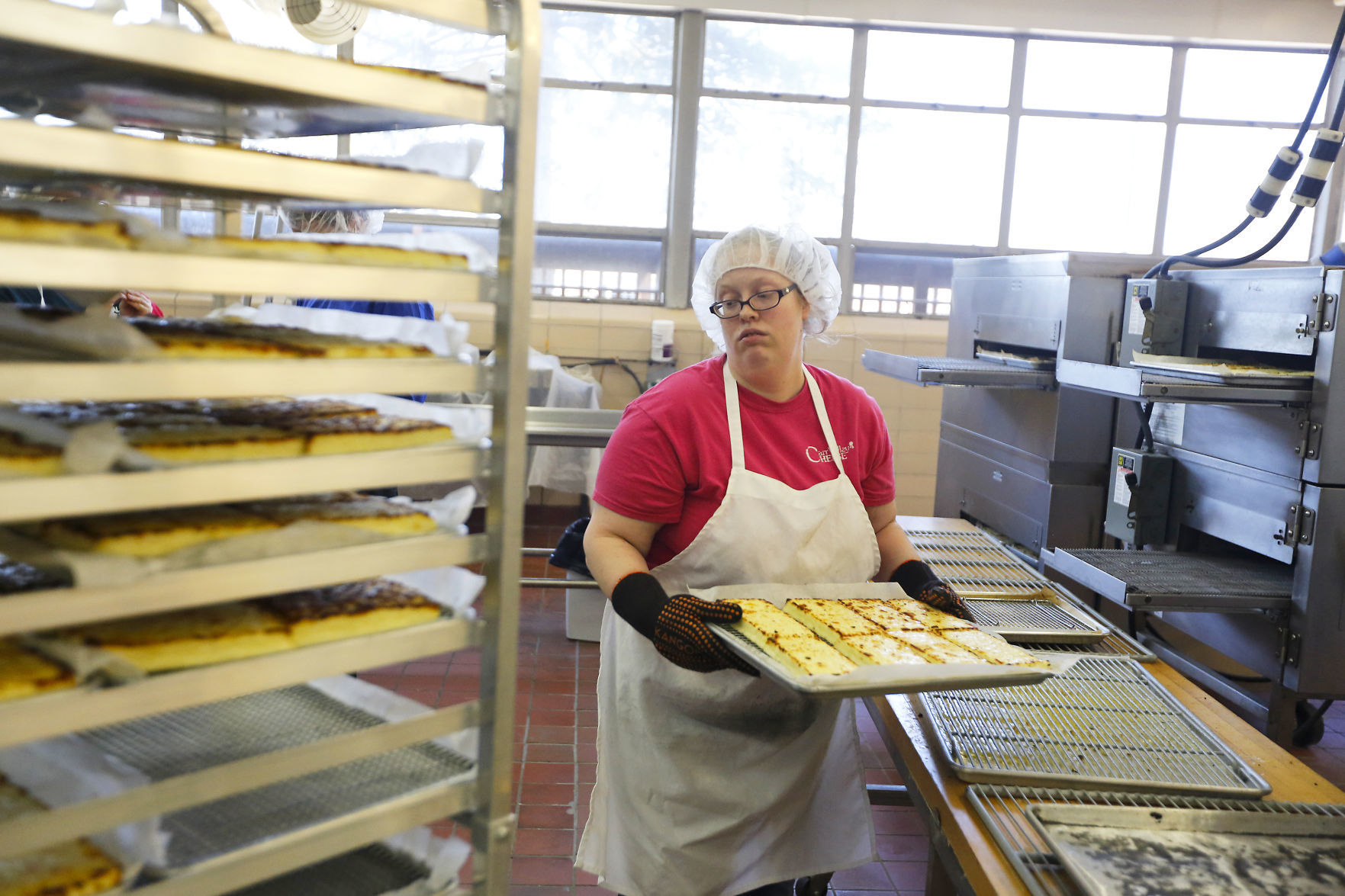Alyssa Campbell, of Fennimore, Wis., takes bread cheese out of the oven at Carr Valley Cheese Company in Fennimore on Thursday, Mar. 22, 2018.    PHOTO CREDIT: EILEEN MESLAR
