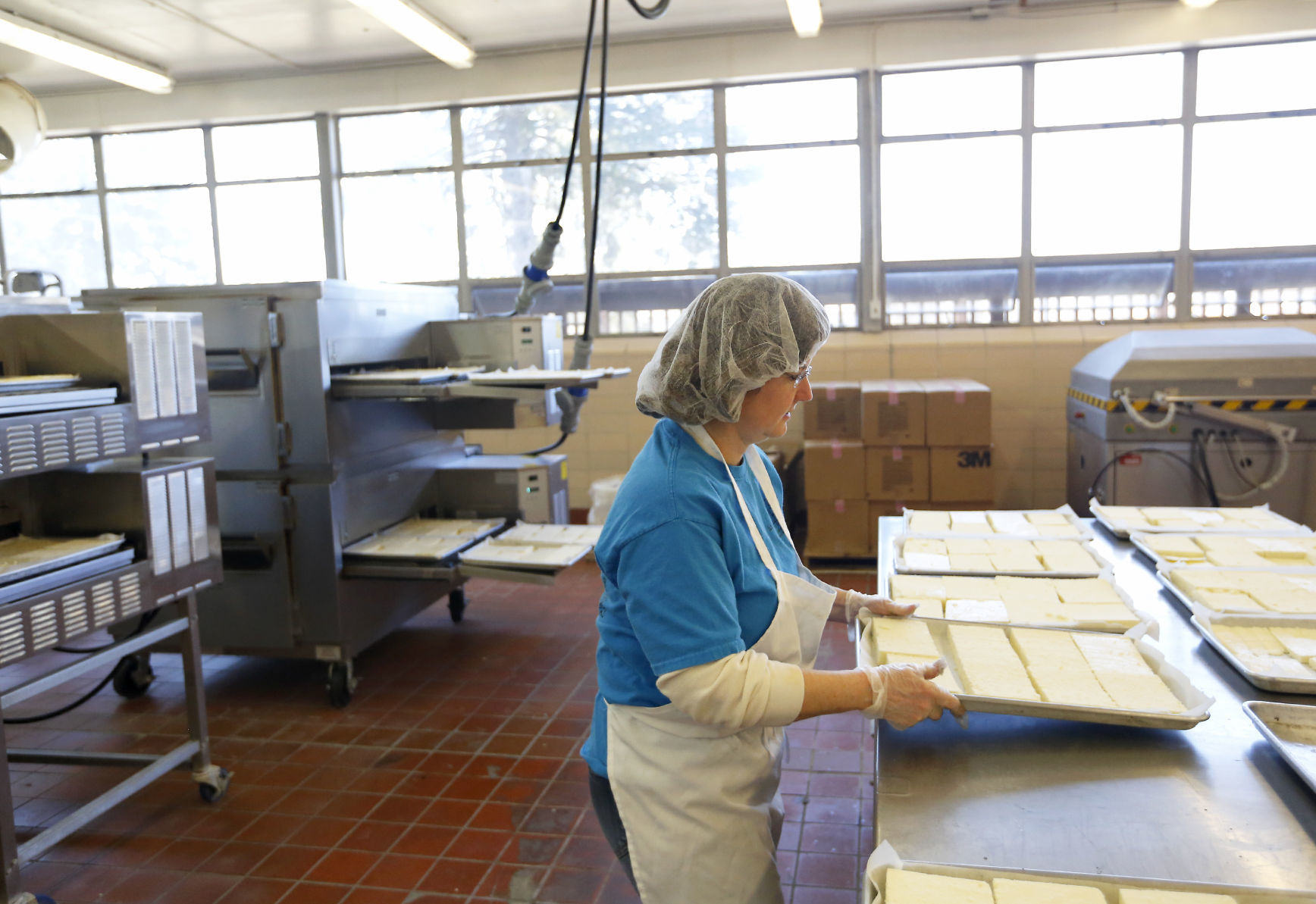Cathy LaMore gets ready to put cheese in the oven at Carr Valley Cheese. The company’s Fennimore, Wis., facility has been open since 2005. It employs 10 and has increased production through several efficiencies.    PHOTO CREDIT: EILEEN MESLAR