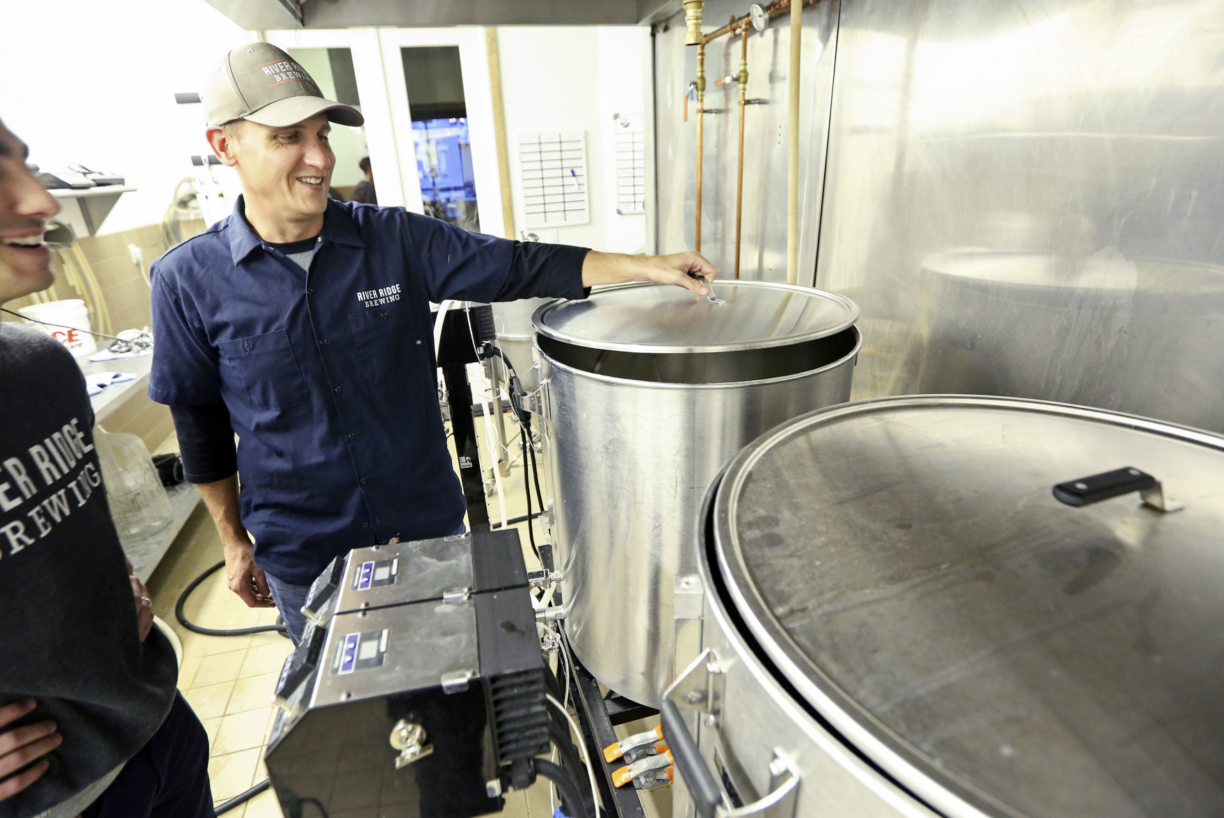 Co-owner Nick Hueneke check on grains as part of the brewing process at River Ridge Brewing in Bellevue, Iowa. The business uses a one-barrel system, which is capable of brewing more than 30 gallons. The business has become a favorite among passing tourists and loyal local customers alike.    PHOTO CREDIT: NICKI KOHL