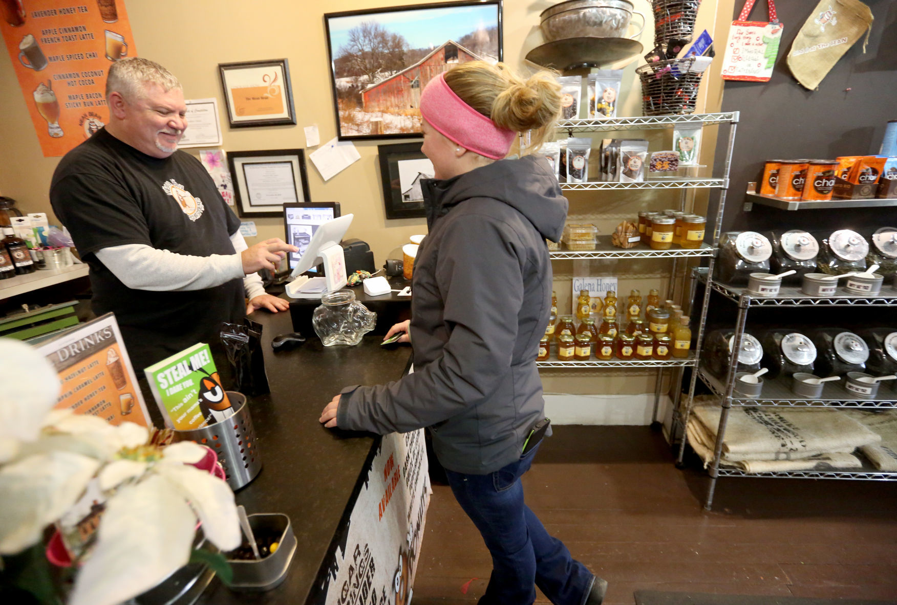 Andrew Carver helps Laura Meyer with an order at Mean Bean Roasters. His Galena, Ill., business provides more than coffee. He shares information on how it is created, and customers are able to watch the roasting process.    PHOTO CREDIT: JESSICA REILLY