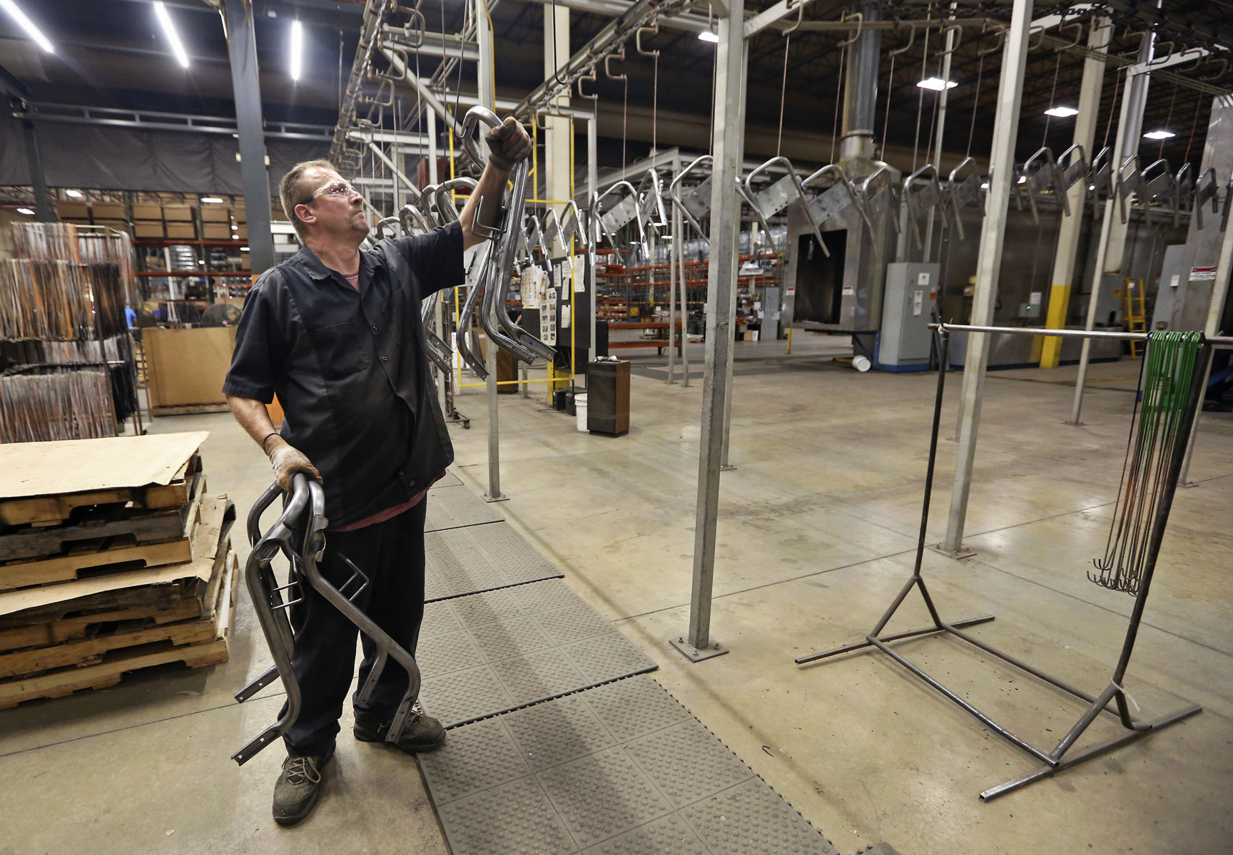 Mike Wienen hangs power washer handles to be painted at Mi-T-M Corporation in Peosta, Iowa, on Monday, June 24, 2019.    PHOTO CREDIT: NICKI KOHL