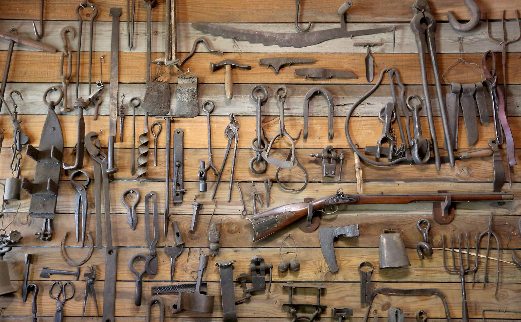 Antique hand-forged farm tools hang on a wall at Prairie Forge.    PHOTO CREDIT: JESSICA REILLY