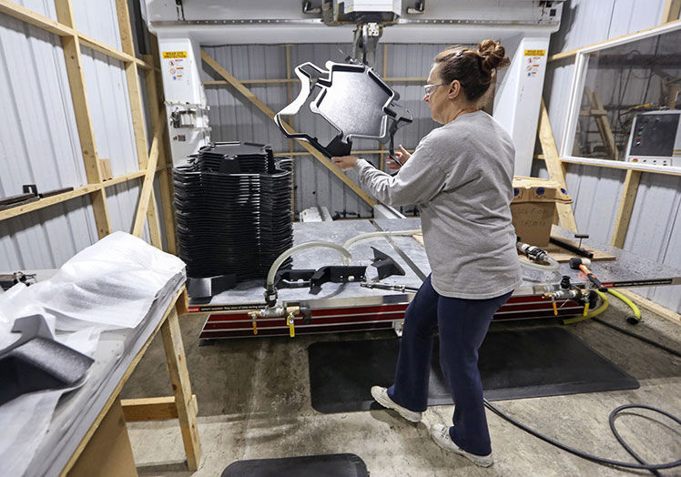 Nancy Yaddof moves a trimmed plastic piece from a CNC at Plastics Unlimited in Preston, Iowa, on Thursday, Nov. 21, 2019.    PHOTO CREDIT: NICKI KOHL