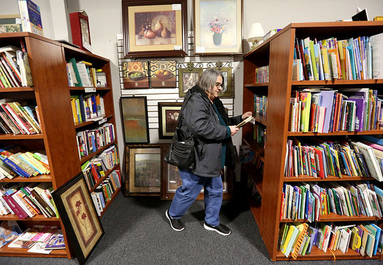Patty Johnson, of Dubuque, browses books at Stuff Etc in Dubuque. PHOTO CREDIT: JESSICA REILLY