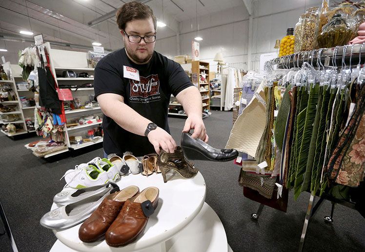 Tory Richard arranges shoes on a display at Stuff Etc. in Dubuque on Wednesday, Dec. 11, 2019. PHOTO CREDIT: JESSICA REILLY