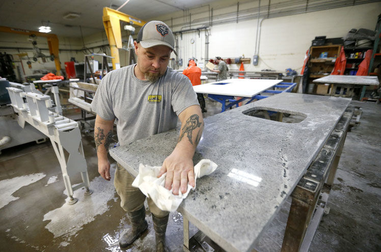 Rickey Carner cuts a piece of granite at Mountaintop Stoneworks. The Dubuque business was started more than 20 years ago by Bob Breitbach and Eric Christensen. It makes items such as countertops and shower products out of a variety of stone.    PHOTO CREDIT: Dave Kettering