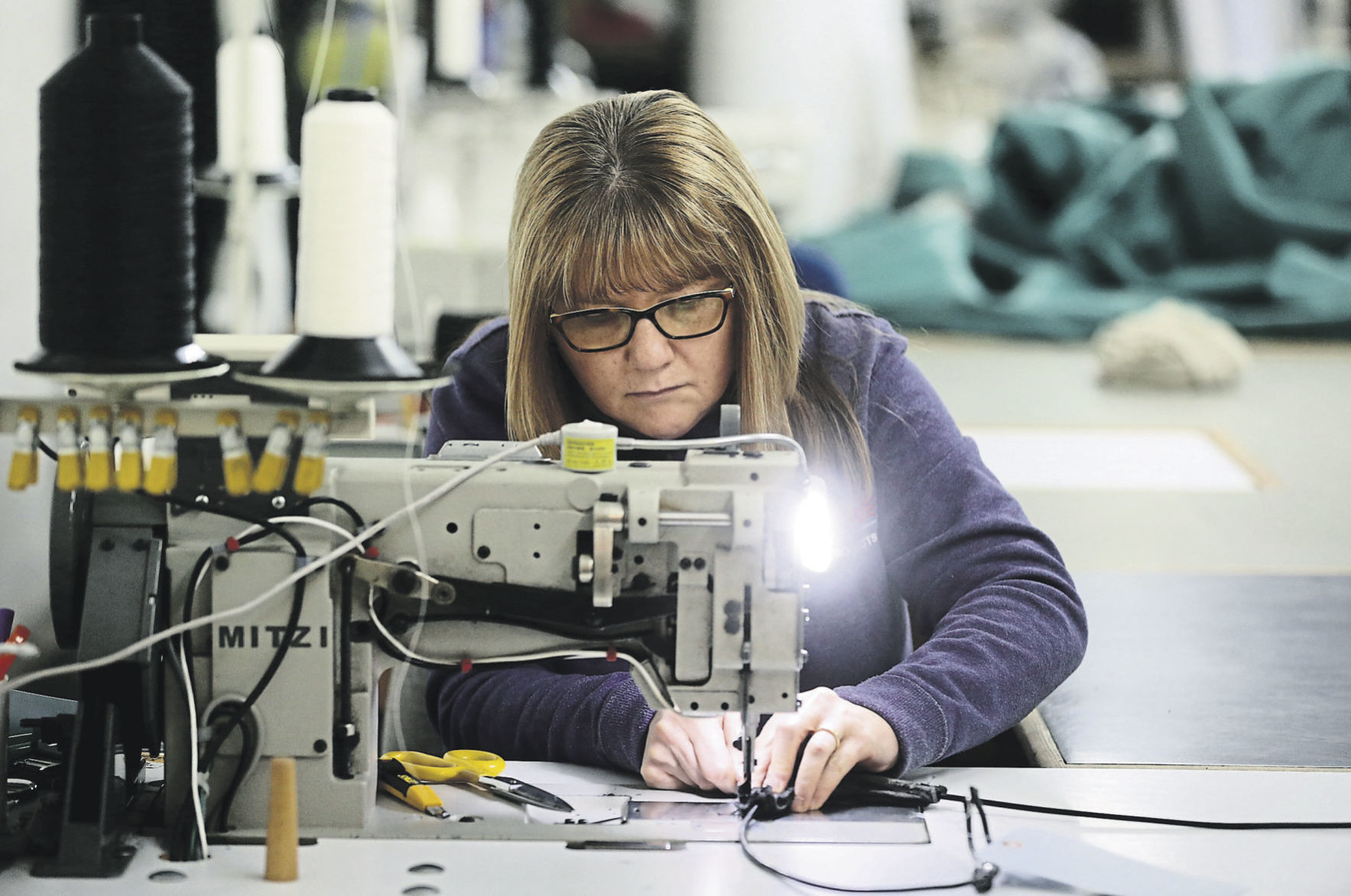Mary Ann Salwolke sews a product. Most are made from an acrylic fabric or hybrid vinyl.    PHOTO CREDIT: JESSICA REILLY