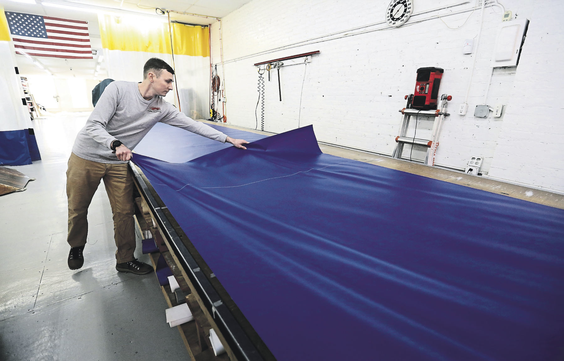 Jacob Salwolke works with a piece of vinyl at Canvas Products Co. The Salwolke clan has owned the business for nearly 50 years. The company produces a number of products, with its awnings the most prevalent. Through the decades, the company has sought to incorporate new technologies and processes.    PHOTO CREDIT: JESSICA REILLY
