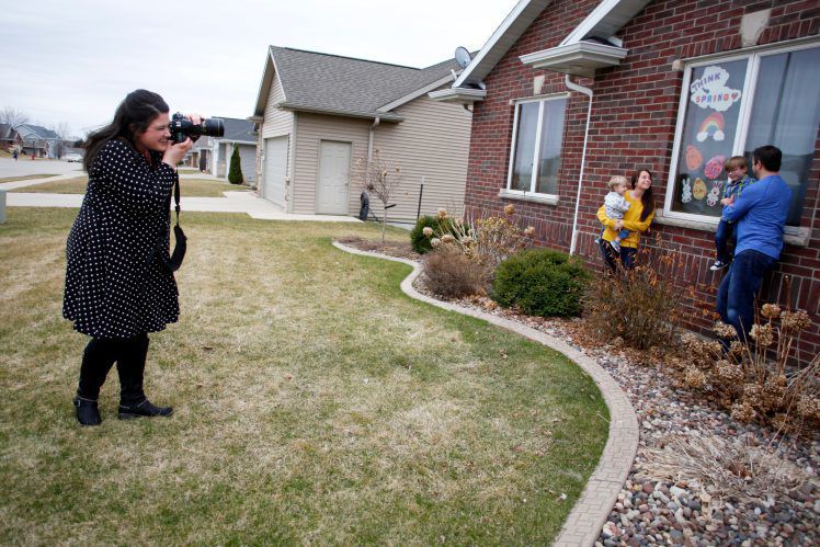 Haley Kolle, of Haley Marie Photography, takes photos of the Weber family on Friday outside their home in Asbury, Iowa. PHOTO CREDIT: EILEEN MESLAR