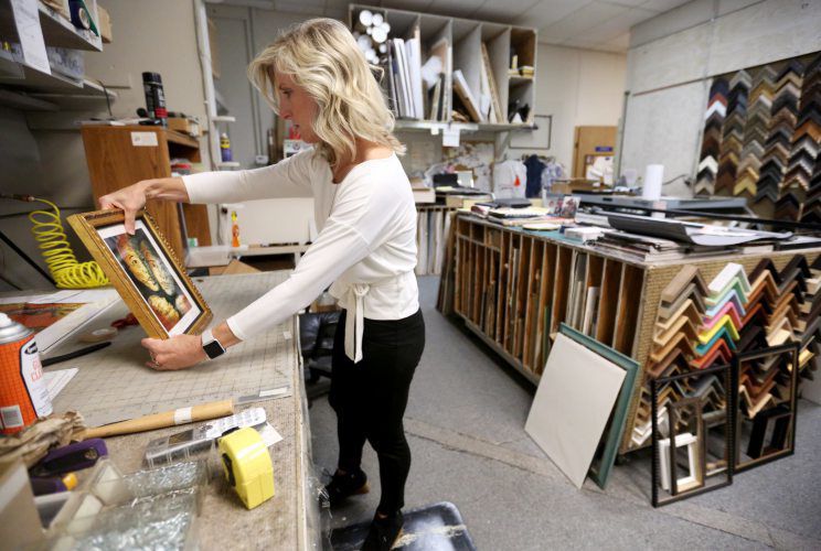 Michele Hefel works on an order at A Frame of Mind Framing & Gallery in Dubuque. PHOTO CREDIT: JESSICA REILLY