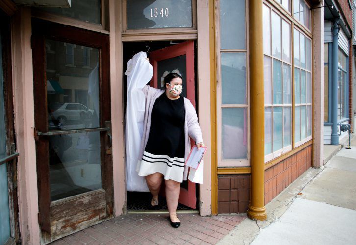 Shelby Duggan, owner of Vintage Chic Bridal Boutique, is doing virtual appointments and curbside pickup for dresses. Photo taken outside of her store in Dubuque on Friday, April 17, 2020. PHOTO CREDIT: EILEEN MESLAR