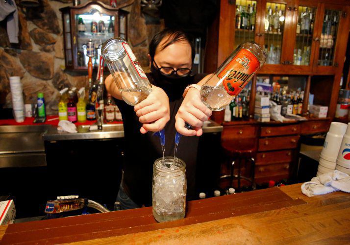 Bartender Scott Jacobs makes a Long Island iced tea at Dubuque Mining Co. in Dubuque on Friday. Long Island iced teas are one of the specialty to-go mixed drinks offered by the restaurant during the pandemic. PHOTO CREDIT: EILEEN MESLAR