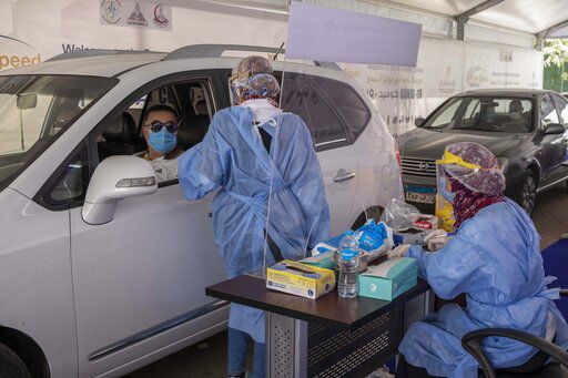 A health worker wearing protective gear prepares to take swab samples from people queuing in their cars to test for the coronavirus at a drive-through COVID-19 screening center at Ain Shams University in Cairo, Egypt, Wednesday, June 17, 2020. (AP Photo/Nariman El-Mofty) PHOTO CREDIT: Nariman El-Mofty