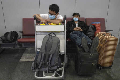 Passengers wait for their flight at the Beijing Capital Airport terminal 2 in Beijing on Wednesday, June 17, 2020. The Chinese capital on Wednesday canceled more than 60% of commercial flights and raised the alert level amid a new coronavirus outbreak, state-run media reported. (AP Photo/Ng Han Guan) PHOTO CREDIT: Ng Han Guan