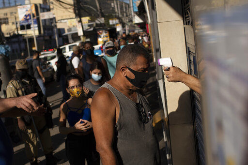 A man gets his temperature checked before entering the Madureira market amid the new coronavirus pandemic in Rio de Janeiro, Brazil, Wednesday, June 17, 2020. Rio continues with its plan to ease restrictive measures and open the economy to avoid an even worse economic crisis. (AP Photo/Silvia Izquierdo) PHOTO CREDIT: Silvia Izquierdo