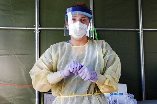 A medical worker prepares to administer a COVID-19 virus test at a drive-thru care testing site at the Derry Medical Center on Wednesday, June 17, 2020 in Derry, New Hampshire. (AP Photo/Charles Krupa) PHOTO CREDIT: Charles Krupa