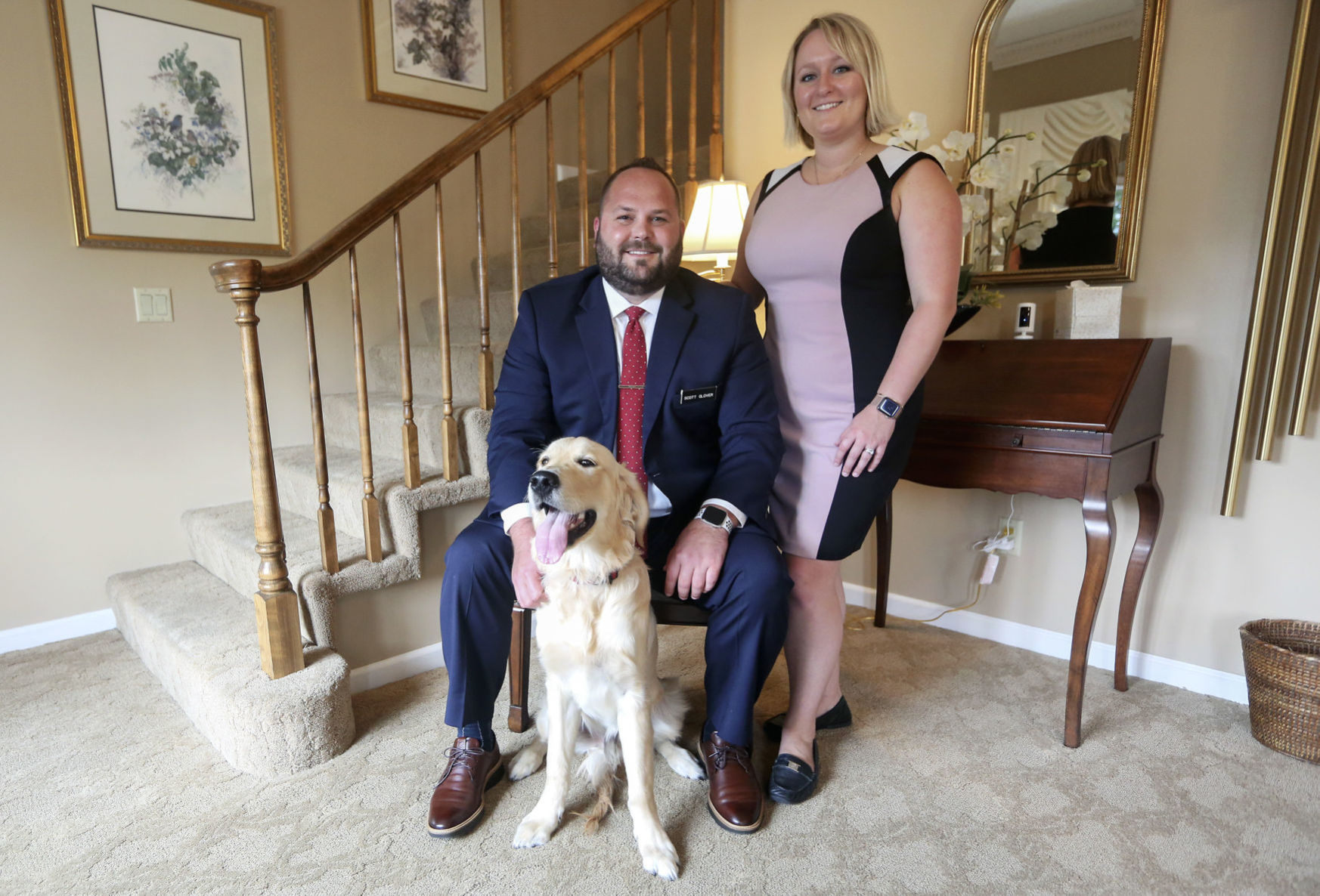 Managing Funeral Director Scott Glover and Office Manager Samantha Glover with their dog, Stanley, at Hoffmann Schneider & Kitchen Funeral Home and Cremation Service in Dubuque, on Friday, June 19, 2020. Stanley is an English golden retriever and comes to the business to provide stress relief for employees and customers. PHOTO CREDIT: NICKI KOHL