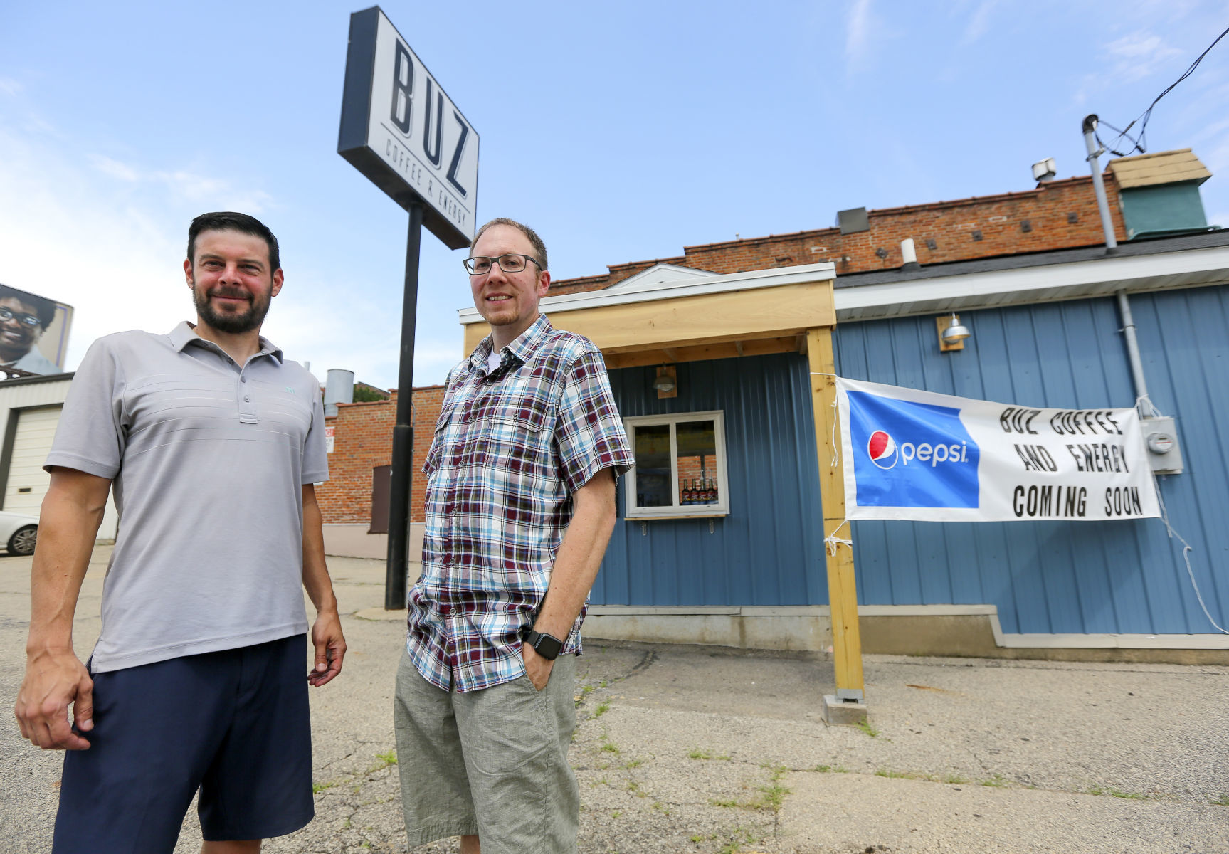 Buz Coffee & Energy owners Tony Hesselman (left) and Jeremy Patrum stand outside of their business in downtown Dubuque. PHOTO CREDIT: Dave Kettering