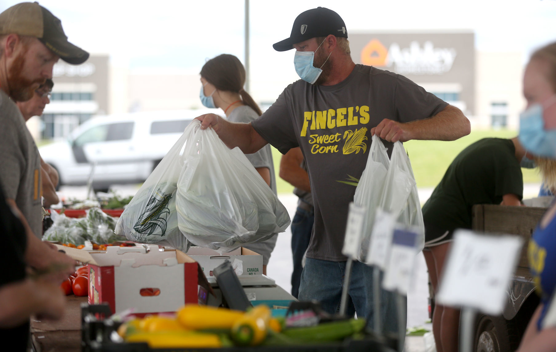 Craig Fincel carries bags of sweet corn during opening day of Fincel