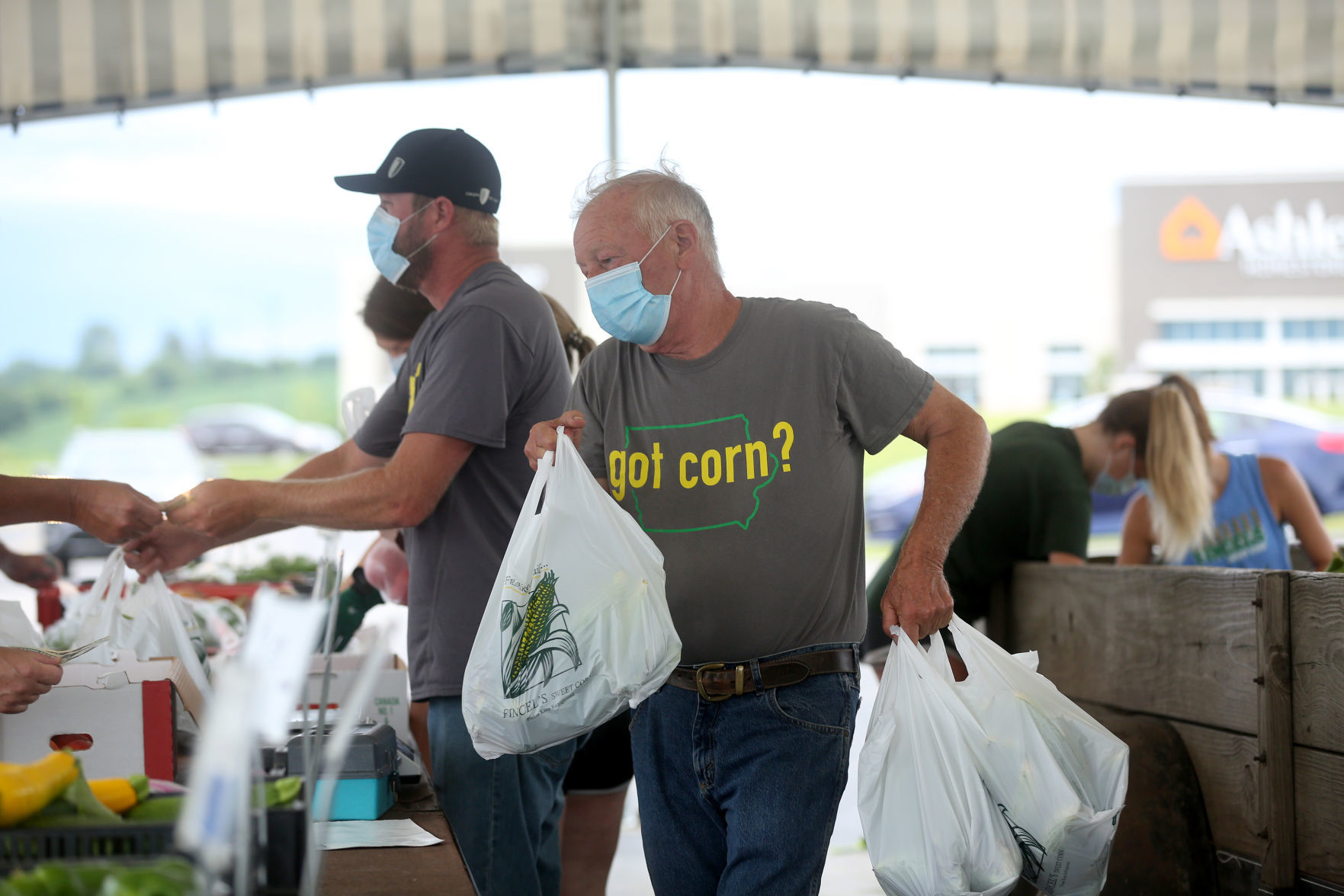 Frank Fincel carries bags of sweet corn during opening day of Fincel