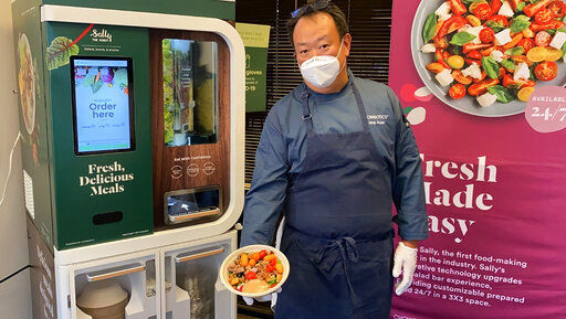 Kang Kuan, vice president of culinary at Chowbotics, holds a custom salad made by his company’s robotic salad-making kiosk at the company’s headquarters in Hayward, Calif., on Tuesday, June 23, 2020. Prior to this year, Chowbotics had sold over 100 of its $35,000 robots, primarily to hospitals and colleges. But since the coronavirus hit, sales have jumped more than 60%, CEO Rick Wilmer said, with growing interest from grocery stores, senior living communities and even the U.S. Department of Defense. (AP Photo/Terry Chea) PHOTO CREDIT: Terry Chea