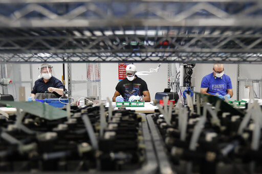 Ford Motor Co. line workers put together ventilators that the automaker is assembling at the Ford Rawsonville plant in Ypsilanti Township, Mich. The Federal Reserve said today that U.S. industrial production rose 5.4% in June, the second straight monthly gain. But it was still 10.9% below the level in February before the economy locked down in the face of the coroanavirus. PHOTO CREDIT: Carlos Osorio