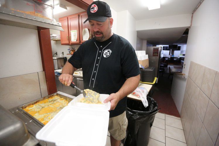 Meyer serves up a to-go lunch for a customer. PHOTO CREDIT: Dave Kettering/Telegraph Herald