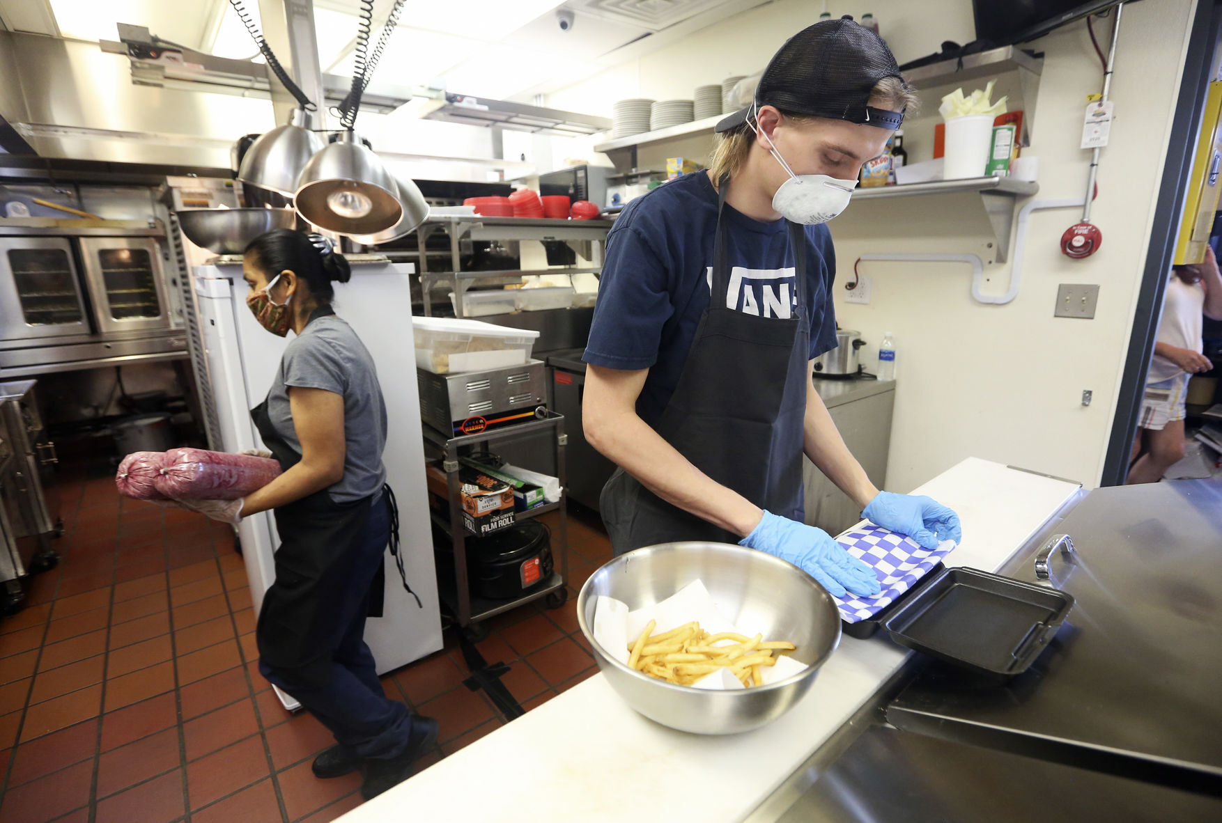 Celia Berez (left) and Hank Peterson prepare food at Frentress Lake Bar & Grill in East Dubuque, Ill., on Thursday, July 16, 2020. PHOTO CREDIT: NICKI KOHL