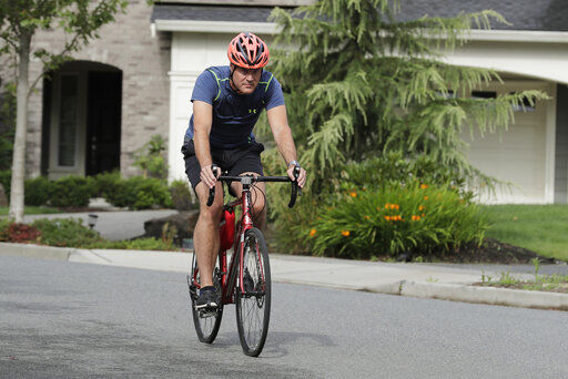 Neal Browning, the second person to receive a trial dose of a COVID-19 vaccine, rides his bike, Friday, July 24, 2020, in Bothell, Wash. As the world
