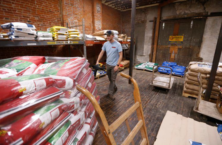Scott Hendricks, sales manager at Hendricks Feed and Seed in Dubuque, works on stocking product. PHOTO CREDIT: Dave Kettering
