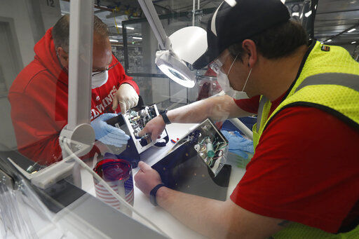 FILE - In this Wednesday, May 13, 2020 file photo, Ford Motor Co. employees work a ventilator at the Rawsonville plant in Ypsilanti Township, Mich. The plant was converted into a ventilator factory, as hospitals battling the coronavirus report shortages of the life-saving devices. According to the Institute for Supply Management, U.S. manufacturing rebounded in June 2020 as major parts of the country opened back up, ending three months of contraction in the sector caused by the coronavirus pandemic. (AP Photo/Carlos Osorio) PHOTO CREDIT: Carlos Osorio