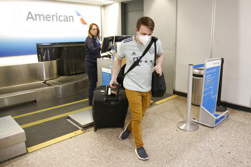 FILE - In this April 30, 2020 file photo, Ethan Cale walks from the American Airlines ticket counter in Salt Lake City. American Airlines is planning to drop flights to up to 30 smaller U.S. cities if a federal requirement to continue those flights expires at the end of next month, an airline official familiar with the matter said Thursday, Aug. 13. (AP Photo/Rick Bowmer) PHOTO CREDIT: Rick Bowmer