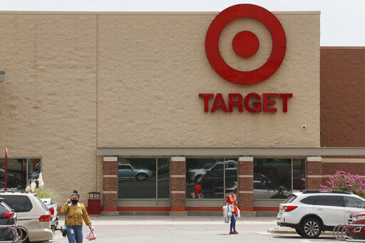 FILE - In this Tuesday, Aug. 4, 2020 file photo, people walk through the parking lot at a Target store in Oklahoma City. Target has reported that its sales as measured by a key metric registered their strongest performance to date for the company’s fiscal second quarter. It