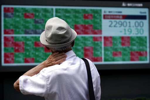 A man looks at an electronic stock board showing Japan