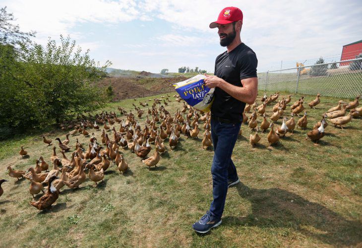 Owner Jeff Friedman feeds the ducks at Treeline Farm in Zwingle, Iowa, on Aug. 28. He founded the farm in 2020 and started selling duck eggs to local restaurants, at farmers markets and online. PHOTO CREDIT: NICKI KOHL