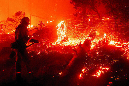 CORRECTS COUNTY TO MADERA COUNTY INSTEAD OF MARIPOSA COUNTY - Embers fly from a tree stump as the Creek Fire burns in the Cascadel Woods neighborhood of Madera County, Calif., on Monday, Sept. 7, 2020. (AP Photo/Noah Berger) PHOTO CREDIT: Noah Berger, The Associated Press