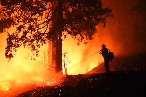 A firefighter uses a hose to try to extinguish flames from a burning structure while fighting the Creek Fire, Sunday, Sept. 6, 2020, in Big Creek, Calif. (AP Photo/Marcio Jose Sanchez) PHOTO CREDIT: Marcio Jose Sanchez