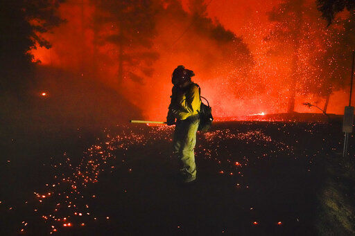 A firefighter covers himself from flying embers while fighting the Creek Fire, Sunday, Sept. 6, 2020, in Big Creek, Calif. (AP Photo/Marcio Jose Sanchez) PHOTO CREDIT: Marcio Jose Sanchez