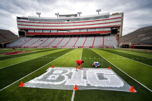 FILE - In this Thursday, Oct. 6, 2011 file photo, turf manager Jared Hertzel touches up the newly-painted Big Ten conference logo on the football field at Memorial Stadium in Lincoln, Neb. Big Ten is going to give fall football a shot after all. Less than five weeks after pushing football and other fall sports to spring in the name of player safety during the pandemic, the conference changed course Wednesday and said it plans to begin its season the weekend of Oct. 23-24. (Jacob Hannah/Lincoln Journal Star via AP, File) PHOTO CREDIT: Jacob Hannah