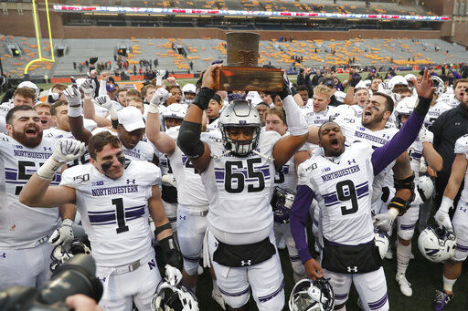 FILE - In this Nov. 30, 2019, file photo, Northwestern celebrates with the Land Of Lincoln trophy after beating Illinois 29-10 in an NCAA college football game in Champaign, Ill. Big Ten is going to give fall football a shot after all. Less than five weeks after pushing football and other fall sports to spring in the name of player safety during the pandemic, the conference changed course Wednesday, Sept. 16, 2020, and said it plans to begin its season the weekend of Oct. 23-24. (AP Photo/Charles Rex Arbogast, File) PHOTO CREDIT: Charles Rex Arbogast