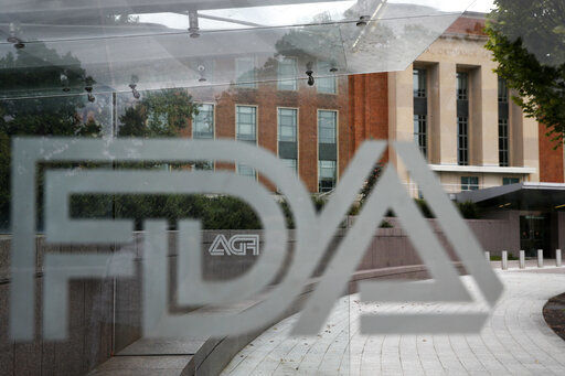 FILE - This Aug. 2, 2018, file photo shows the U.S. Food and Drug Administration building behind FDA logos at a bus stop on the agency
