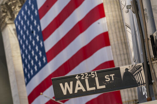 The Wall Street street sign is framed by a giant American flag hanging on the New York Stock Exchange, in a Monday, Sept. 21, 2020 file photo. Stocks are opening higher on Wall Street, recovering after their first four-week losing streak in more than a year. A burst of corporate deals helped give investors confidence to put money back in the market, and the S&P 500 rose 1.4% in the early going Monday, Sept. 28, 2020. (AP Photo/Mary Altaffer, File) PHOTO CREDIT: Mary Altaffer