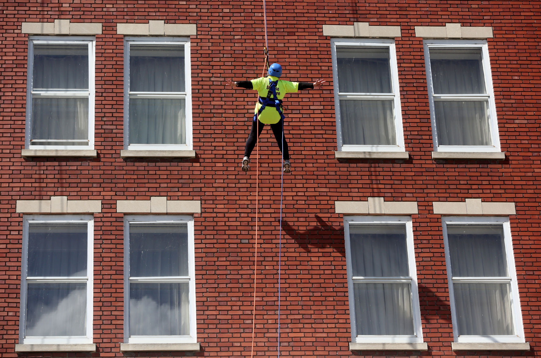 Judy Wolf, of Dubuque, rappels down the side of Hotel Julien Dubuque during United Way of Dubuque Area Tri-States