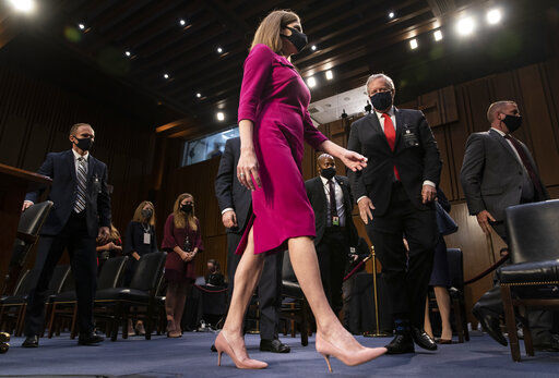 Supreme Court nominee Amy Coney Barrett stands during a break in her confirmation hearing before the Senate Judiciary Committee on Capitol Hill in Washington, Monday, Oct. 12, 2020. At right is White House chief of staff Mark Meadows. (Alex Edelman/Pool via AP) PHOTO CREDIT: Alex Edelman