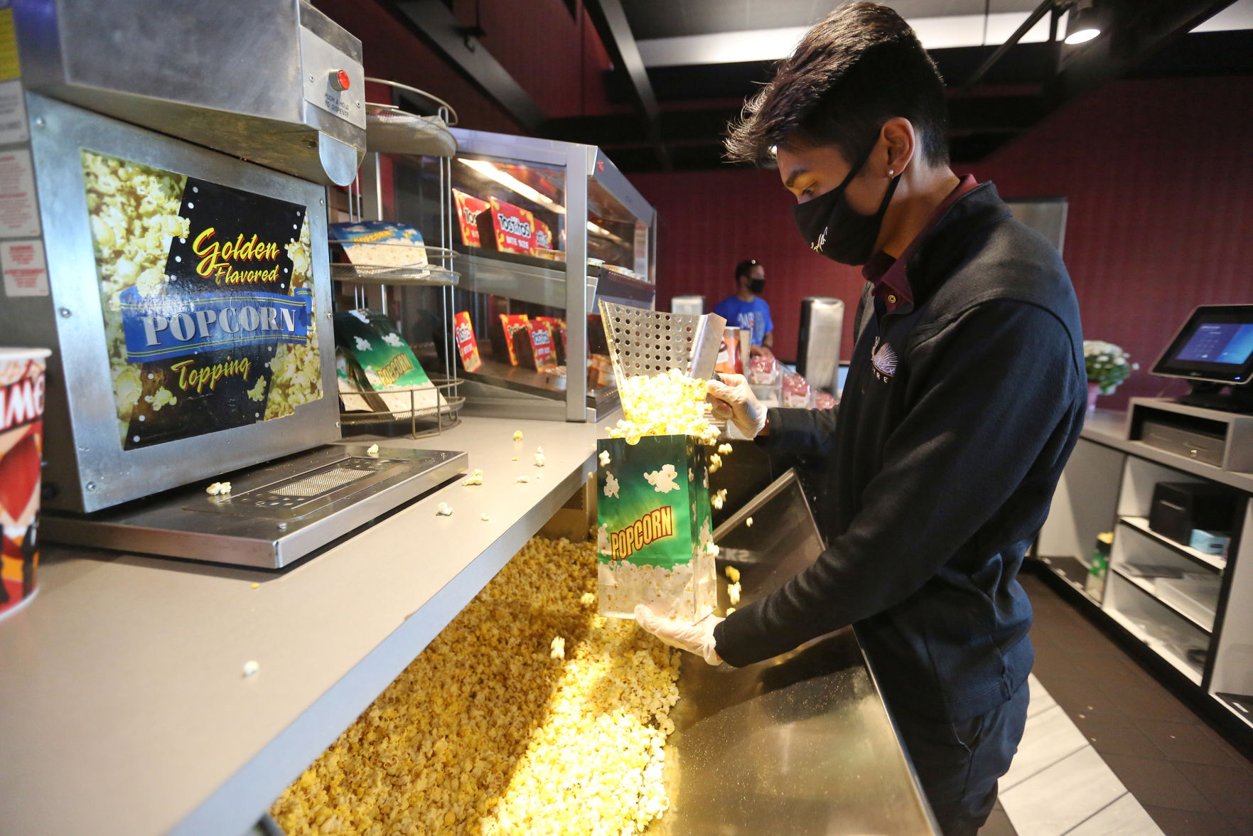 ChipperJosh Villanueva fills popcorn for a customer at Phoenix Theatres in Dubuque on Tuesday, Oct. 13, 2020. PHOTO CREDIT: JESSICA REILLY