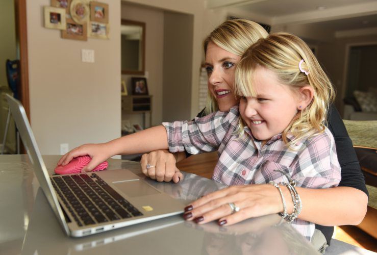 Julia Dapkus and her 8 year old daughter Isabelle doing virtual learning with her fidget mouse. PHOTO CREDIT: Clarence Tabb Jr.